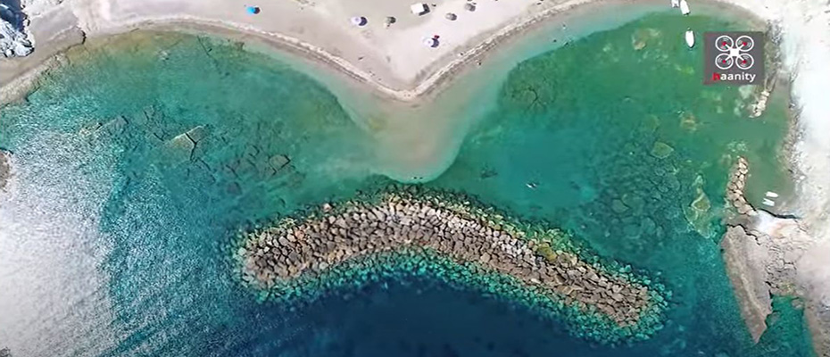 Η άγνωστη παραλία με τον περίεργο κυματοθράστη σε σχήμα «μπανάνας», που τη μετέτρεψε σε παράδεισο