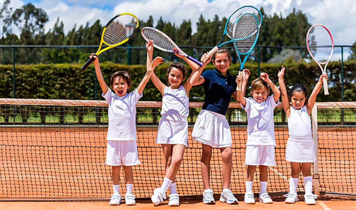 happy group of kids playing tennis