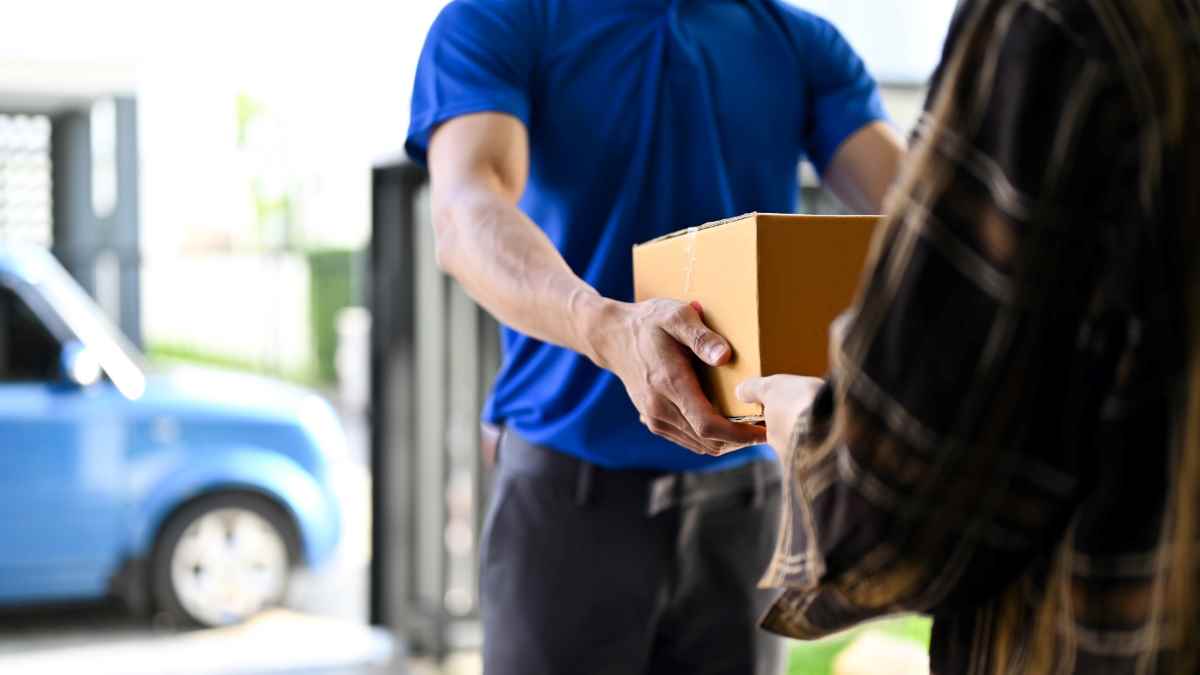 close up view delivery man handing parcel customer while standing front his van